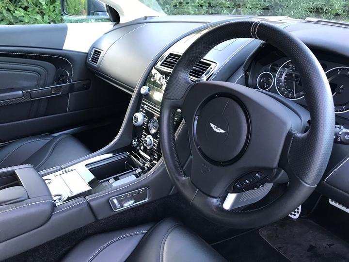 A detailed view of the Aston Martin DBS's elegant and ergonomic steering wheel and dashboard.