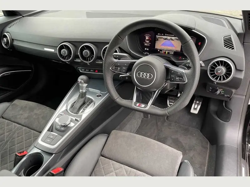Side profile of a white Audi TT for sports car rental.