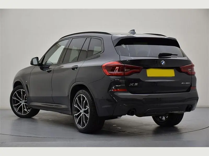 A chauffeur opening the door of a BMW X3 hire car.