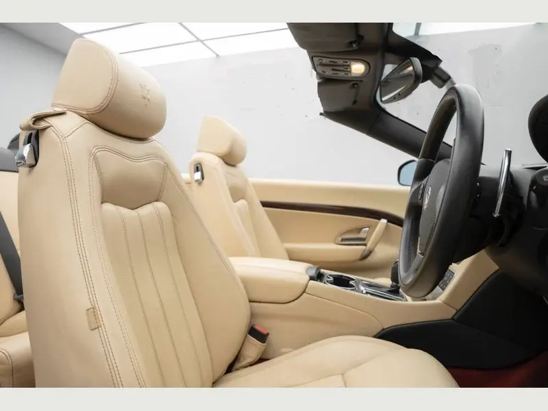 A stylish white Maserati Grancabrio parked on a driveway, ready for a self-drive hire.