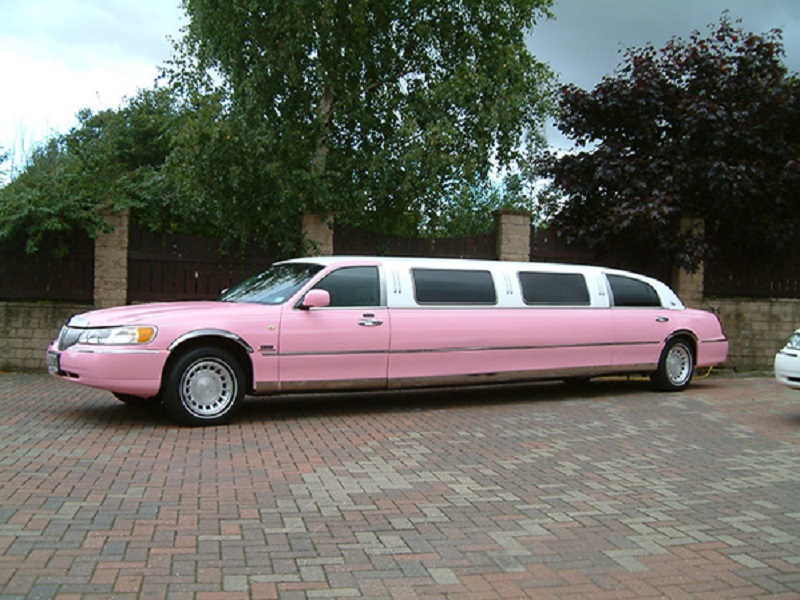 A long pink stretch limousine, perfect for a modern and stylish wedding.